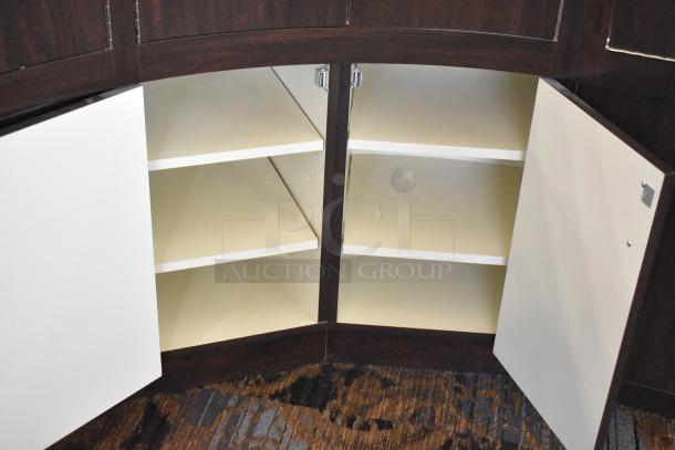 Wooden curved lighted jewelry case with four rear doors, open to show interior shelving. Removal requires tools and manpower.