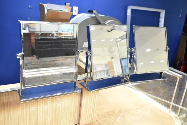 Three countertop mirrors with chrome frames, adjustable angles, in excellent condition, on a wooden surface.