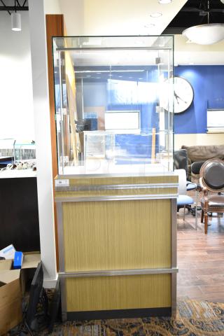 Wooden jewelry case with glass display and two rear doors. Good condition. Buyer must remove; bring tools and manpower.