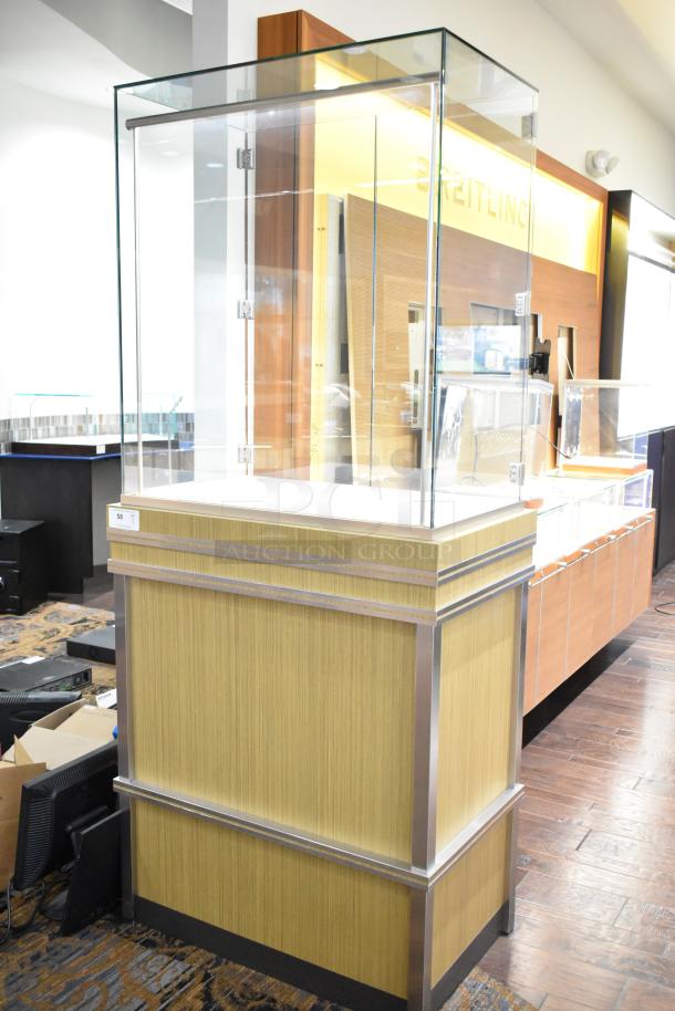 Wooden jewelry case with glass top, two rear doors, and metal trim. Requires tools and manpower for removal.