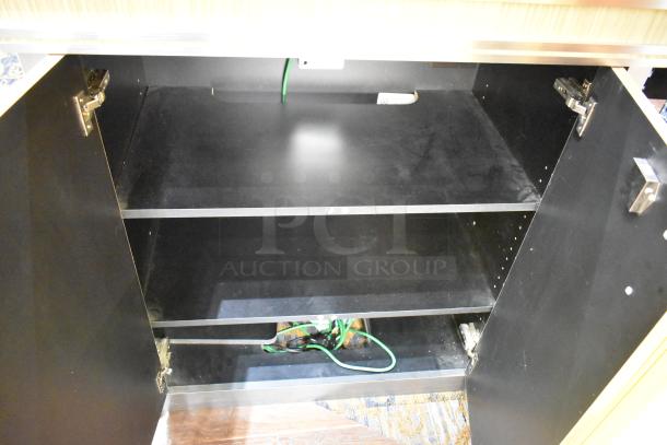 Wooden jewelry case with two rear doors, open to show interior shelving. Appears sturdy; buyer responsible for removal.