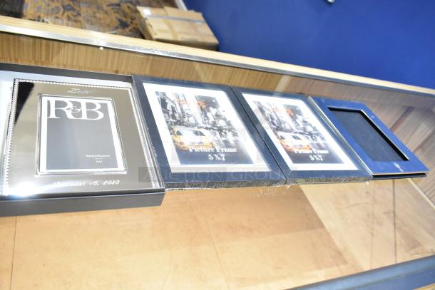 Four picture frames including a Reed & Barton 4x6 frame and three 5x7 frames, displayed on a table.