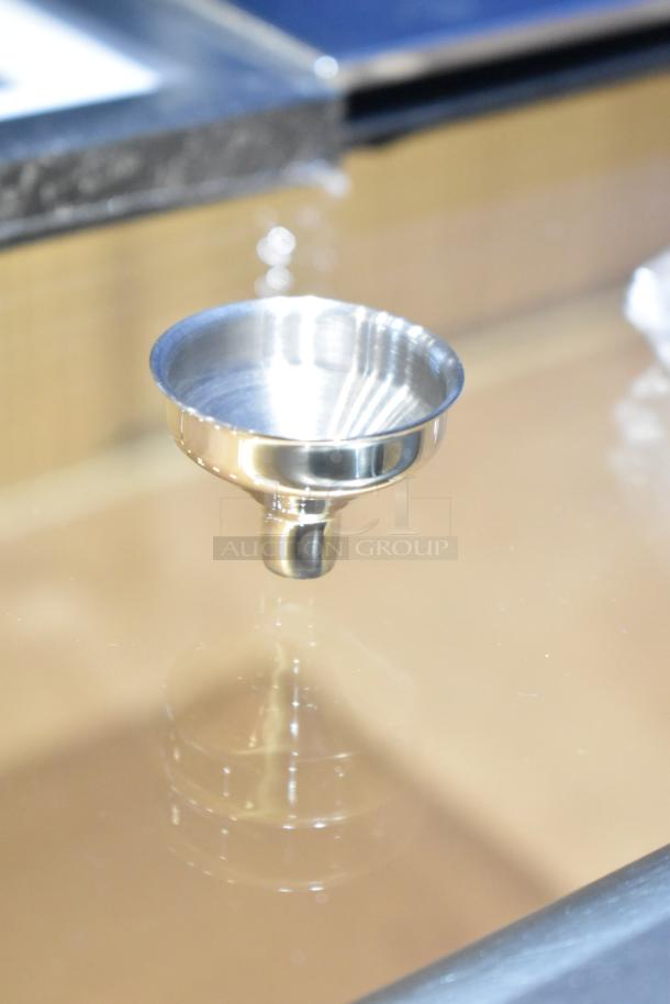 Shiny silver funnel, likely stainless steel, in excellent condition. Part of a lot of 14 items including frames.