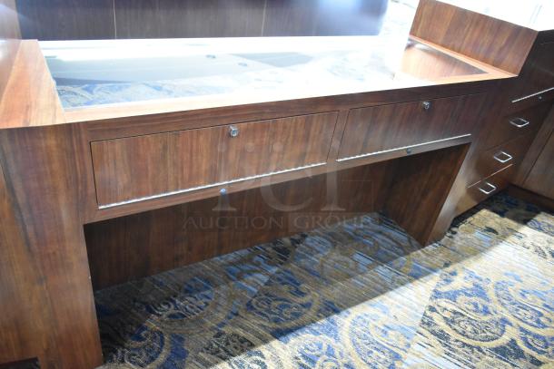 Wooden lighted jewelry case with glass top, drawers, and locking mechanism. Good condition. Tool and manpower needed for removal.