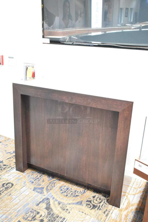 Dark wood desk with a minimalist design, showing a smooth finish and clean lines. Appears in excellent condition.