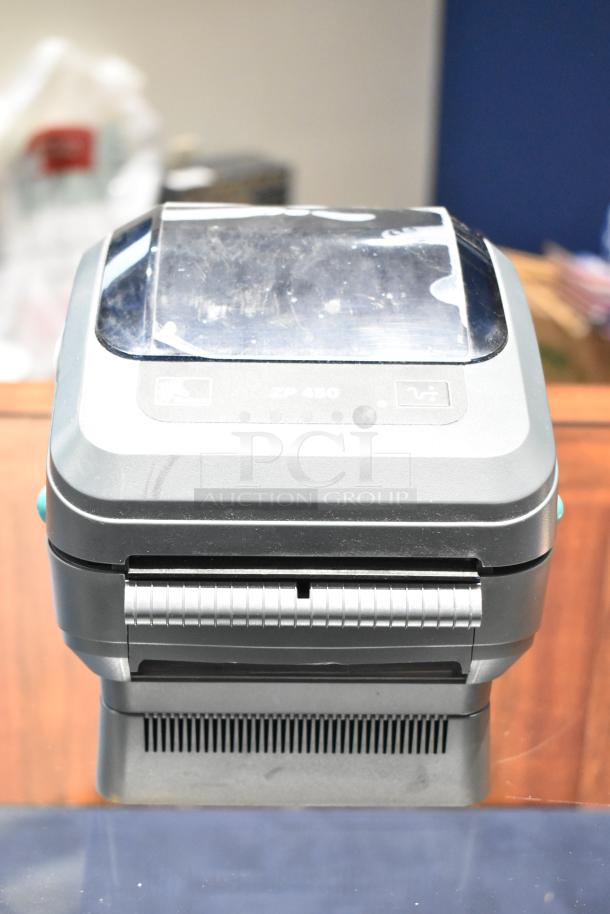 Zebra ZP 450 thermal label printer, gray, slight wear visible, model label on top, compact design for efficient printing.