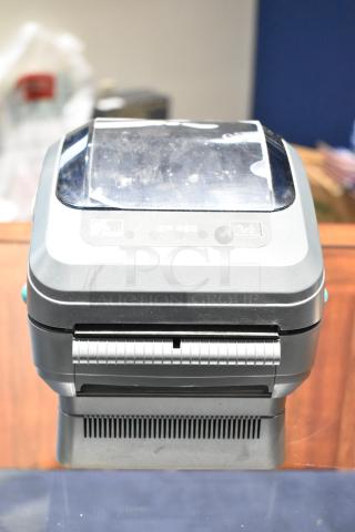 Zebra ZP 450 thermal label printer, gray, slight wear visible, model label on top, compact design for efficient printing.