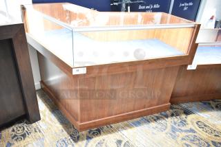 Wooden corner-style lighted jewelry case with glass top, two rear doors, and three drawers. Good condition.