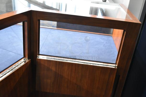 Wooden corner-style lighted jewelry case with glass top, two rear doors, and three drawers. Dark wood finish, in good condition.