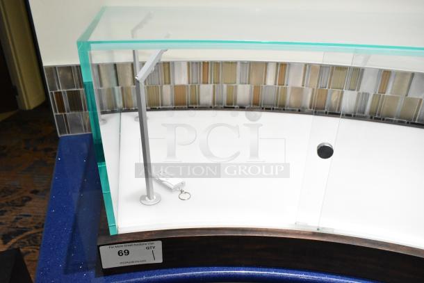 Transparent glass countertop display case with a modern design. Includes a remote control and key. Condition appears excellent.