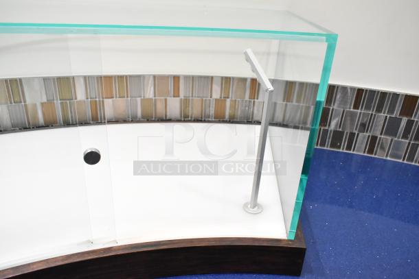 Curved glass countertop display case with metal support, wood base, and modern design. Ideal for showcasing products.