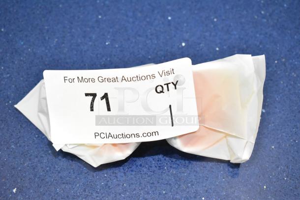 New white framed sunglasses with orange lens in wrapping, auction lot 71, available at PCI Auctions.