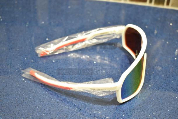 Brand new white-framed sunglasses with orange lenses, plastic-wrapped, showing brand marking.