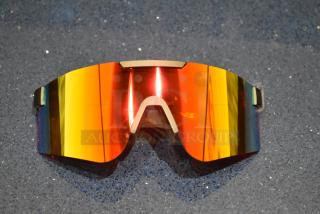 Brand new golden framed sunglasses with sleek orange lenses and a modern design on a blue textured background.