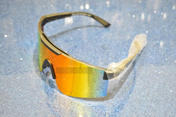 Brand new golden framed sunglasses with orange lens, still wrapped. Modern design, reflective lens, and pristine condition.