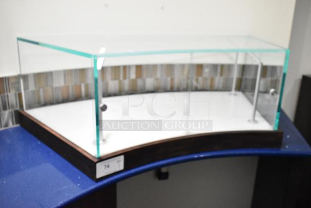 Glass countertop display case with wood base, curved front, and metal supports. Excellent condition. Tag reads "74".