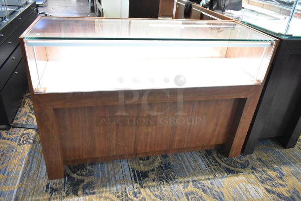 Wooden lighted jewelry case with glass top. Excellent condition. Buyer must provide tools and manpower for removal.