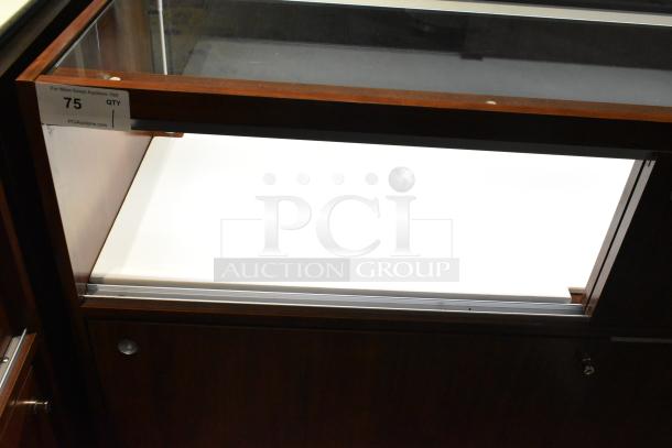 Wooden lighted jewelry case with glass top, dark wood finish, and lower storage. Buyer must bring tools for removal.