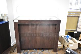 Dark wooden counter with polished surface, simple design, and no visible damage. Tag reading "76". Functional and stylish piece.