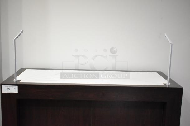 Dark wooden counter with a white top. Metal posts on each end. Auction tag reads "76." Good condition.