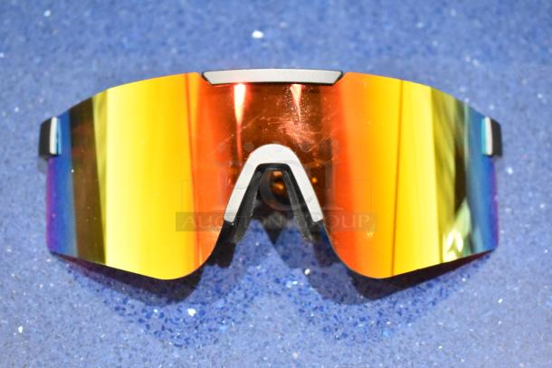 Brand new gray-framed sunglasses with vibrant orange lenses, reflecting a rainbow effect. In pristine condition.