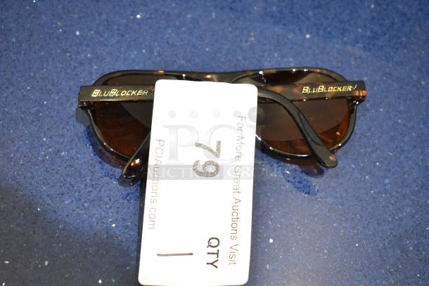 Brand new brown tortoise shell framed sunglasses with BluBlocker brown lens. Tag indicating item number 79 from PCAuctions.com.