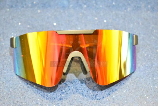 Brand new tan framed sunglasses with vibrant orange lens, reflective finish, and sleek design.
