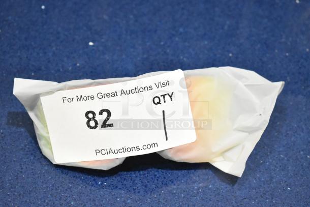 Tan framed sunglasses with orange lenses, brand new, wrapped. Auction label reads "82, QTY 1, PCIAuctions.com."