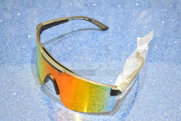 Brand new gray framed sunglasses with orange lens, pristine condition, protective wrap on temple, vibrant and reflective.