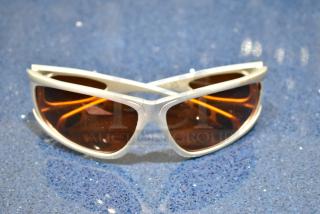 BRAND NEW Viper white framed sunglasses with BluBlocker orange lenses on blue speckled surface.