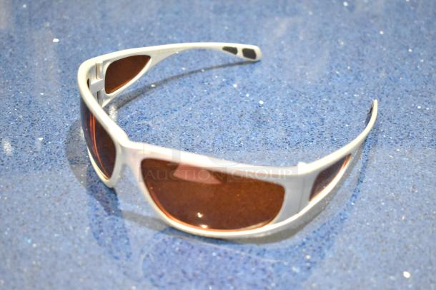 BRAND NEW Viper sunglasses with white frame and BluBlocker orange lenses on a blue surface.