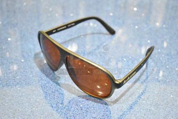 Brand new gray framed sunglasses with BluBlocker orange lenses, featuring sleek design and logo on the arm.