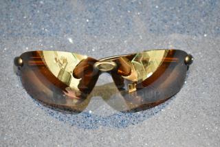 Brand new gray framed sunglasses with BluBlocker brown lenses, reflecting surface details.