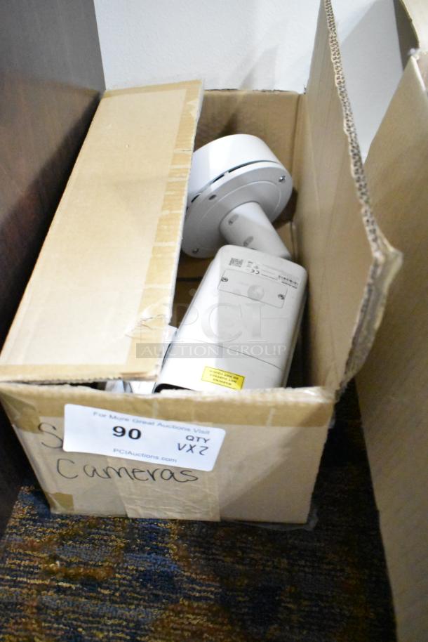 Two network cameras in a box: Hikvision DS-2CD7A26G0/P-IZHS and NC-KDO32 IR. Condition appears unused. Auction lot 90.