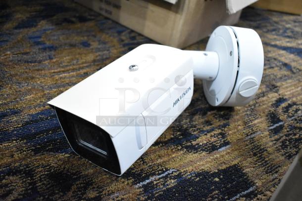 Hikvision DS-2CD7A26G0/P-IZHS network camera, white, with mounting base, shown on a patterned carpet.
