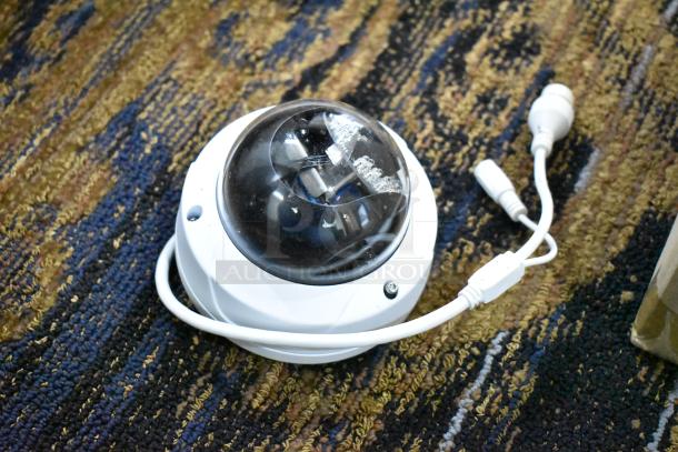 Hikvision DS-2CD7A26G0/P-IZHS network camera, dome style, with visible cables on carpet, in good condition.