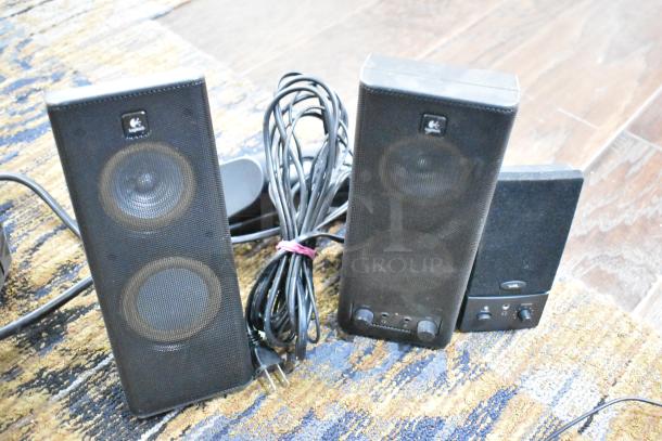 Logitech speakers set, two tall black speakers with visible control knobs and cables. Good condition, branded with Logitech logo.