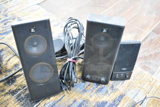 Logitech speakers set, two tall black speakers with visible control knobs and cables. Good condition, branded with Logitech logo.