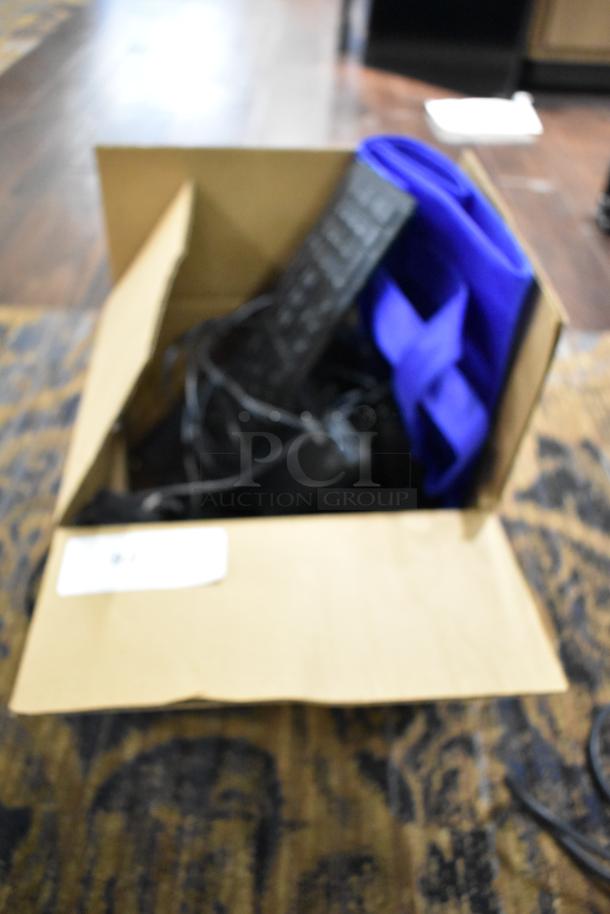 Box containing various items including Logitech speakers, computer keyboard, and additional electronics. Items appear used.