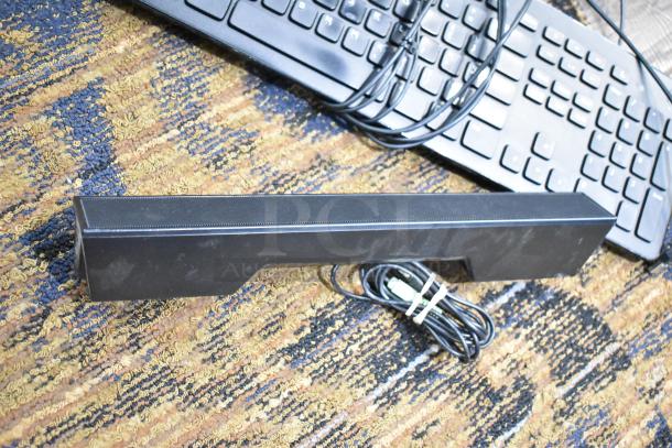 6 various items including Logitech speakers and computer keyboard on patterned carpet. Items include cables and appear gently used.