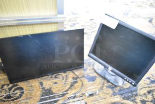 Two computer monitors: Samsung S24R356FHN color display and Dell E172FPb, with cords, shown on a carpeted floor.