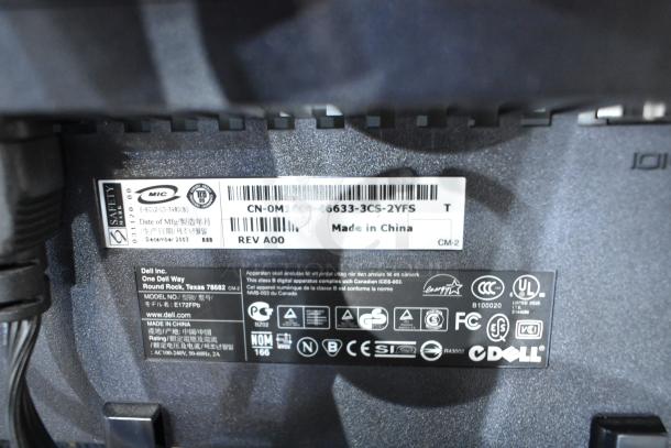 Close-up of the Dell E172FPb monitor label showing model and manufacturing details, part of a two-screen auction lot.