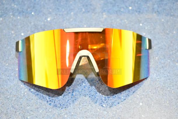 Golden framed sunglasses with orange mirrored lens, brand new. Stylish and modern design with protective UV features.