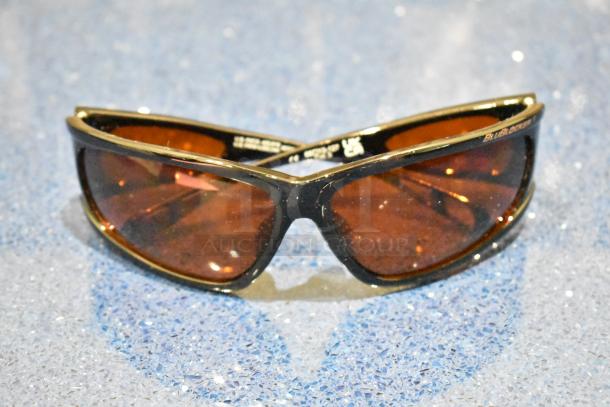 Brown framed sunglasses with BluBlocker orange lens, brand new. Sleek design, marked with BluBlocker logo.