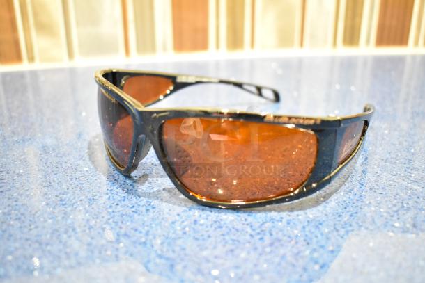 Brown framed sunglasses with BluBlocker orange lenses, brand new condition, curved design for a stylish look.