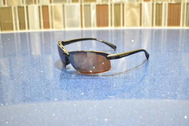Brand new gray framed sunglasses with BluBlocker brown lenses, sleek design, perfect condition, logo visible on temple.
