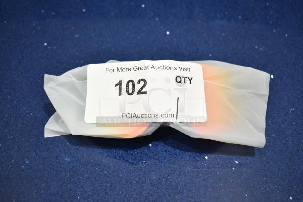 Brand new gray framed sunglasses with BluBlocker orange lens, wrapped in paper with auction label showing "102 QTY".