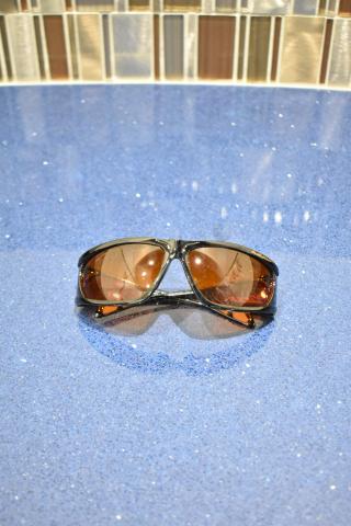 Brand new Viper sunglasses with brown frame and BluBlocker brown lenses on a blue surface.