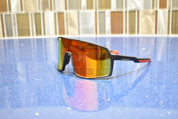 Brand new gray-framed sunglasses with BluBlocker orange lens, sleek design, reflective coating, pristine condition.