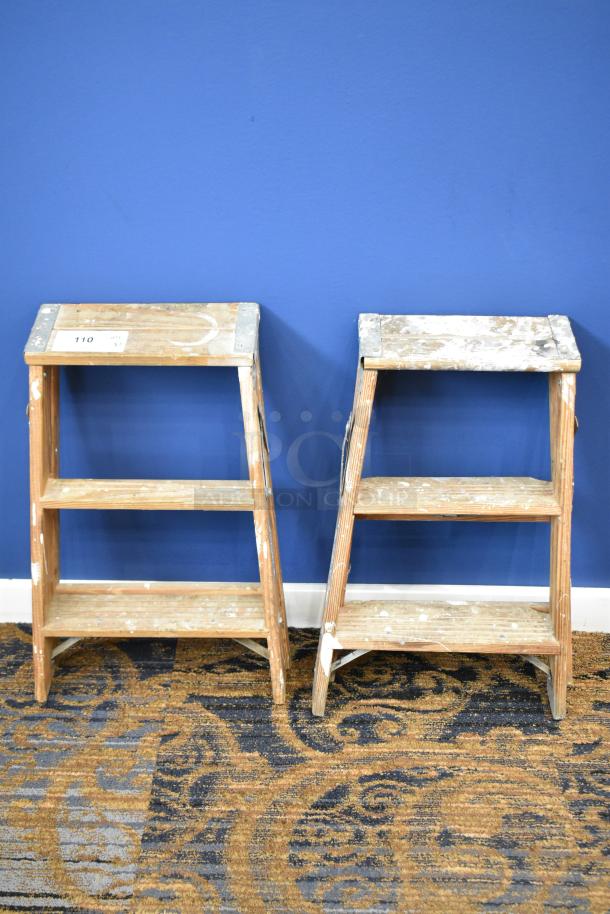 Two 2-foot wooden ladders, including a Werner W130-4, 200 lb capacity. Noticeable wear and paint marks.